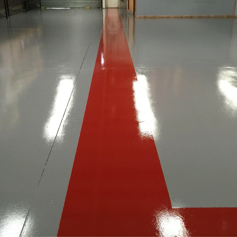 A freshly applied, glossy high-build epoxy flooring in a warehouse or garage setting.