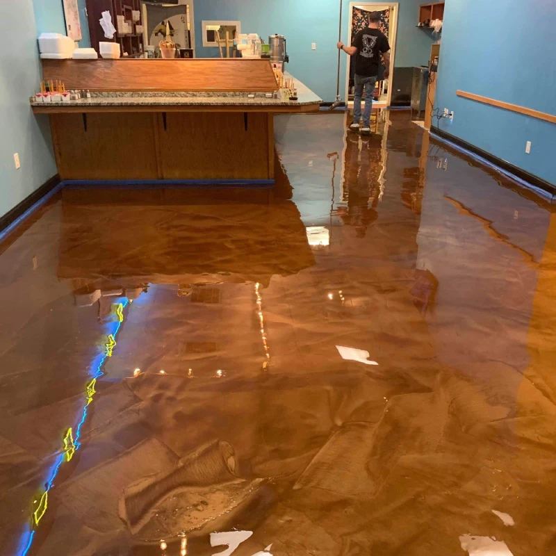 A glossy, reflective cementitious epoxy flooring with a unique, marbled brown and bronze finish.