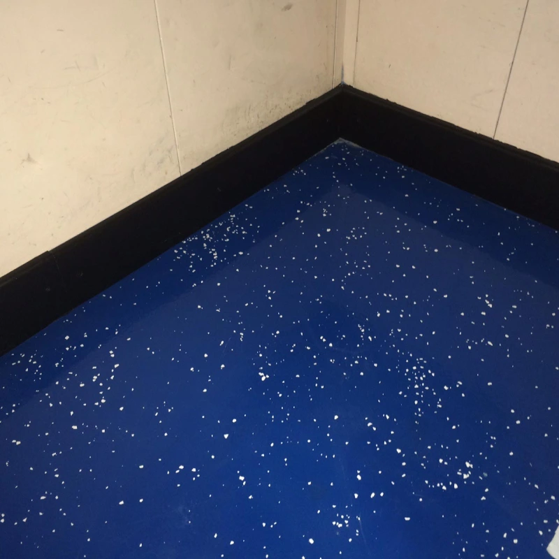 A close-up, high-angle shot of the corner of a room, showcasing a durable Marine epoxy flooring system.