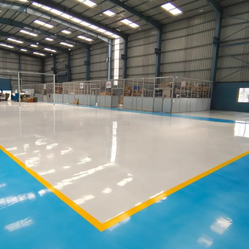 A vast, well-lit industrial warehouse or manufacturing facility featuring a clean, seamless, and Heavy-Duty epoxy flooring system.