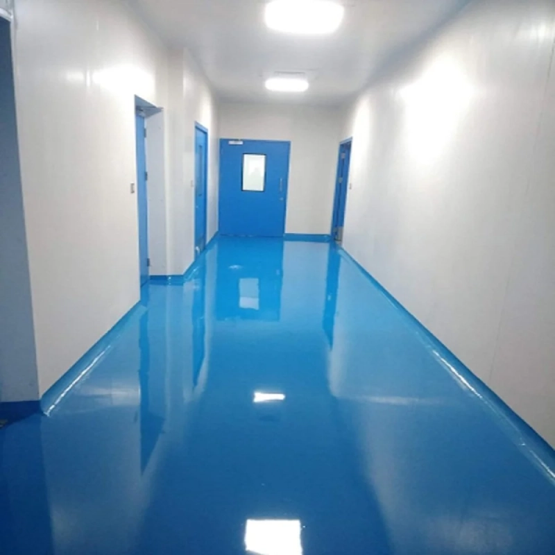 A well-lit hallway with white walls and a striking, highly reflective blue epoxy flooring that incorporates coving where the floor meets the wall.