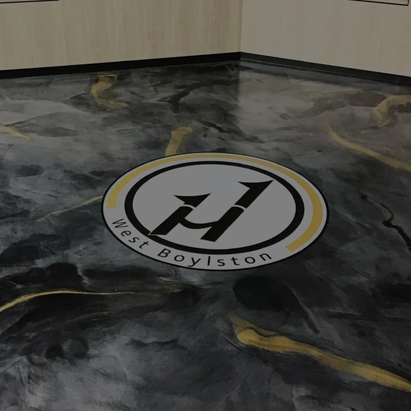 Logo embedded epoxy flooring is featured prominently in the center of the image with a circular logo that has a white background